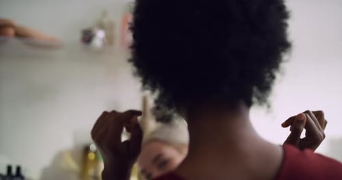 Stylish black woman tries on yellow sunglasses for friend in boutique clothing store