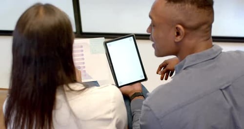 Discussing project, colleagues using tablet and reviewing documents in office, copy space