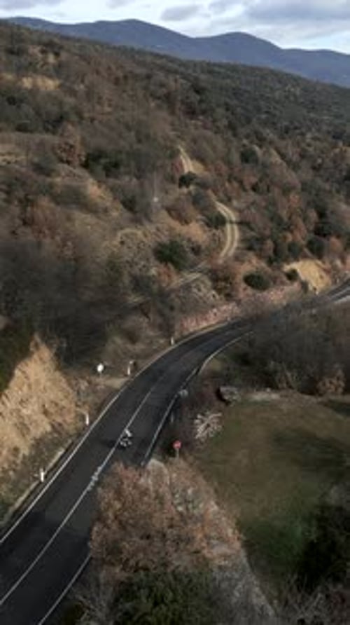 Drone Captures a Motorbike Travelling Along a Mountain Road