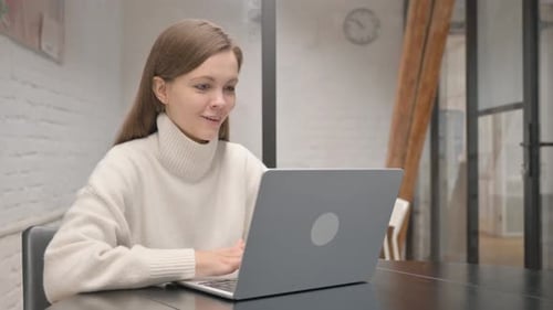 Woman Celebrates Success While Working on Laptop