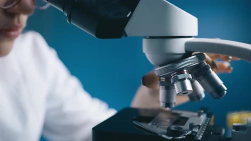 Woman Using Microscope in Medical Laboratory Setting