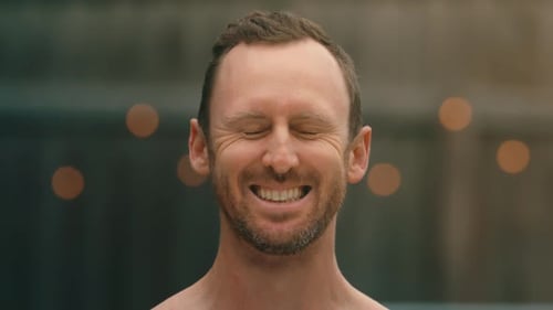 Man hit by 2 pink water balloons in the face without breaking, close up in extreme 4k 800fps slow mo