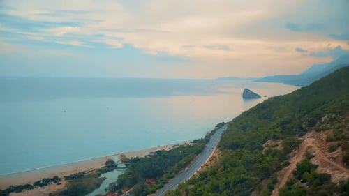 Aerial View of Coastal Highway Along a Scenic Seashore at Sunset