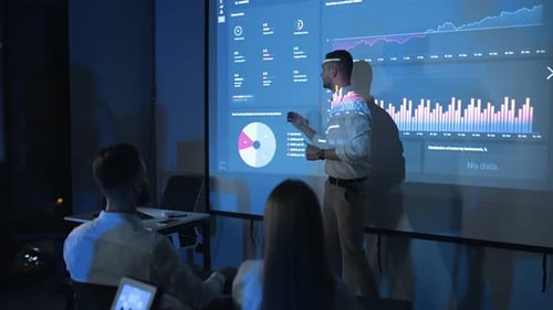 Business Presentation with Team and Presenter in Dark Room