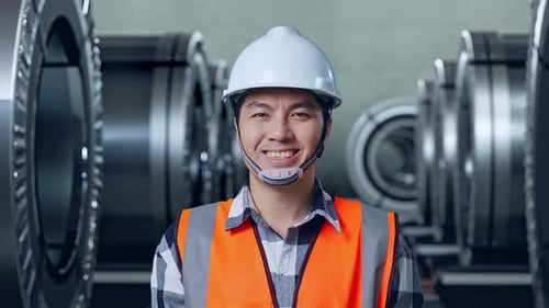 Close Up Of Asian Male Engineer Smiling To Camera In Metal Factory