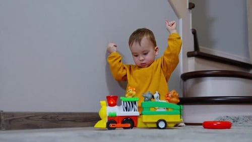 Cute Baby Playing with a Toy Train at Home