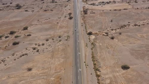 Cars driving on a Desert road surrounded by dry land, Aerial view