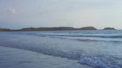 Meer mit Küstenlinie im Hintergrund zur blauen Stunde