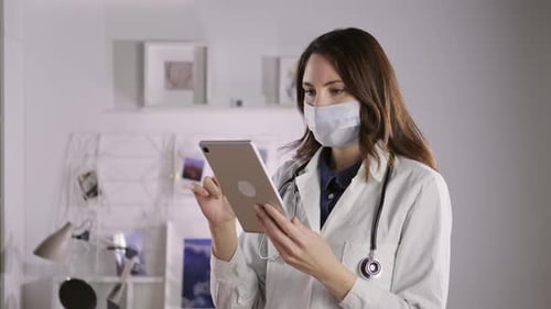 Doctor Uses Tablet in Modern Medical Office