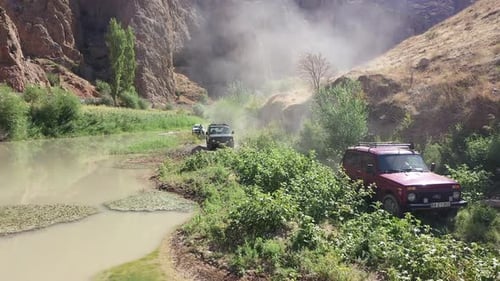 Aerial View Of Offroad Vehicles Driving In Green Area By Creek