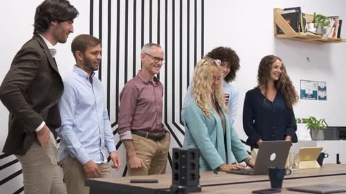 Team Applauding for Businesswoman After Presentation on Laptop in Office