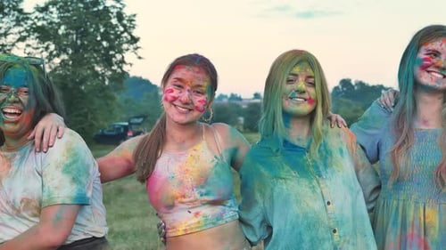 Friends Covered with Colorful Powder Paint are Hugging and Celebrating Holi Festival