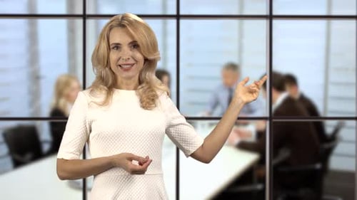 Portrait of an Attractive Blonde Woman Shows Copy Space in Office