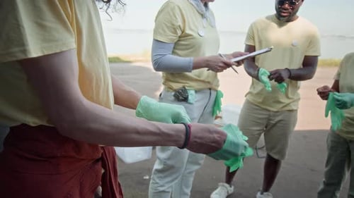 Environment Volunteers Putting on Rubber Gloves before Forest Cleanup