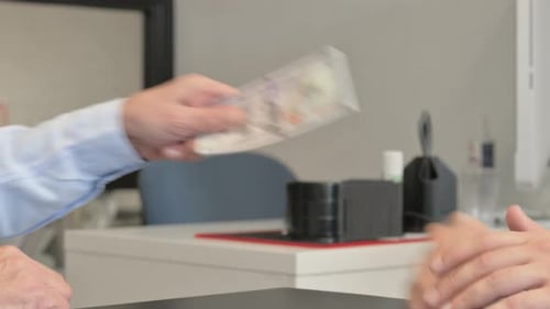 Close Up of Old Businessman Giving Money to Young Man