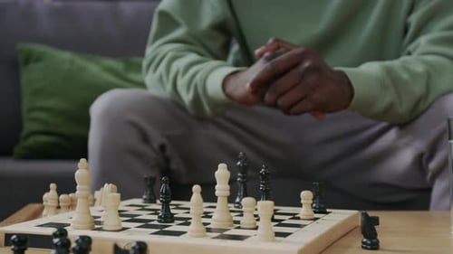 Pensive Man Looking at Chess Board and Thinking about Game Strategy