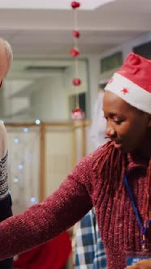 Store Worker Helping Shopper with Clothing During Christmas