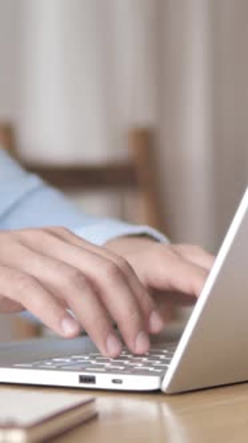 Hands opening and typing on silver laptop keyboard