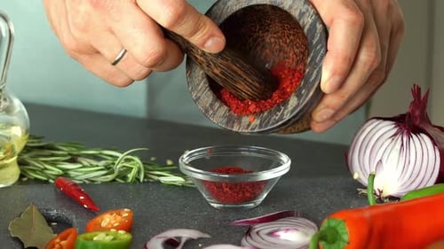 Hands Grind Red Hot Peppers in Mortar Paprika Chilli Spices and Seasonings