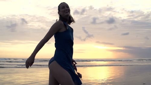 Frau tanzt freudig am Sunset Beach