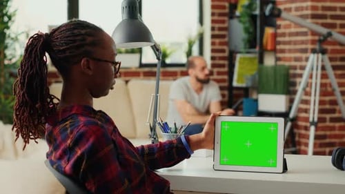 Woman Holding Tablet with Green Screen at Desk