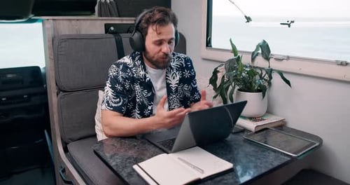 Man Working Remotely on Laptop inside Camper Van