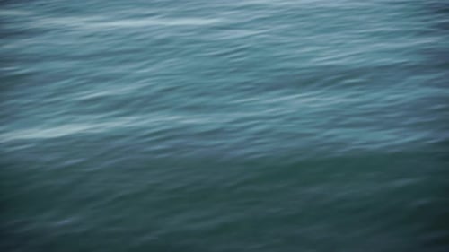 Calm ocean waves roll in, turquoise blue sea, slow motion