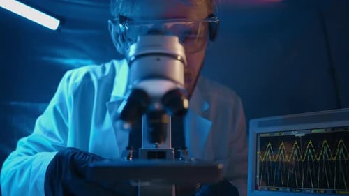 Scientist Examining Specimen with a Microscope in Laboratory