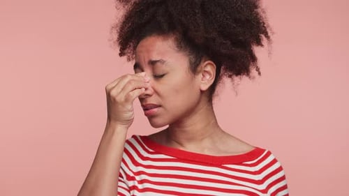 Young Woman Touches Bridge of Nose with Headache