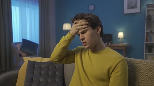 Man Suffering from a Headache at Home