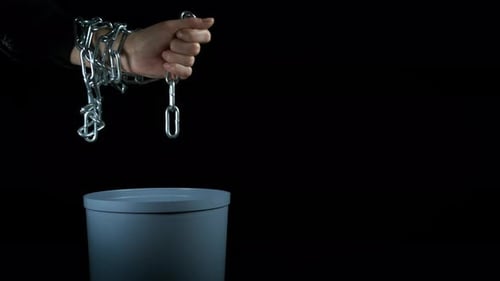 Chained Hand Drops Chain Into Trash Can