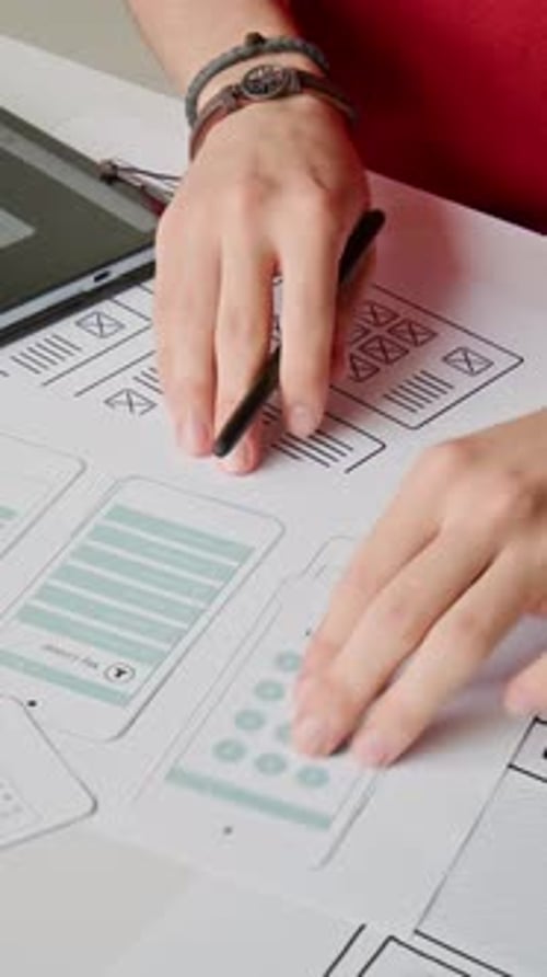 Man Designing Mobile App UI on Tablet and Paper