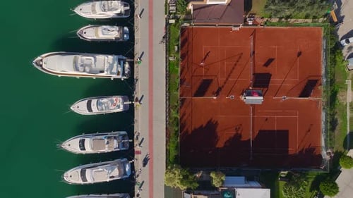 Aerial Video Aerial Perspective of a Tennis Club With White Yachts Docked in a Picturesque Port