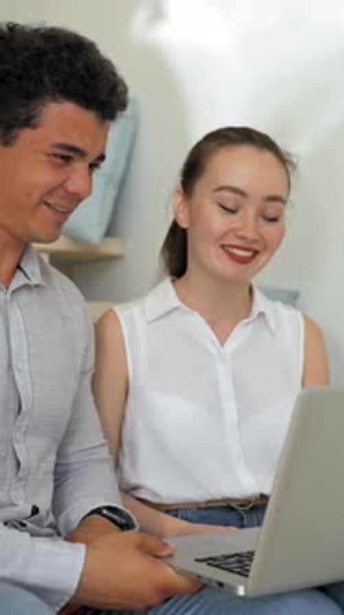 Smiling Couple Using Laptop Together Indoors