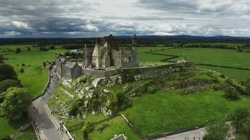 Aerial drone shot of castle and grassy landscapes in Ireland.