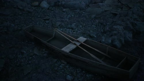 Bote de remos rústico de madera descansando en una costa rocosa
