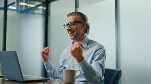 Glad Man Celebrating Success at Workplace Close Up. Successful Businessman Rejoicing Making