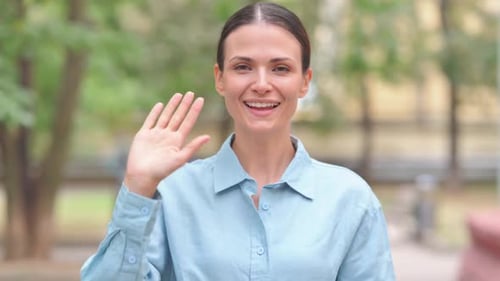 Einladende Frau winkt zur Begrüßung mit der Hand