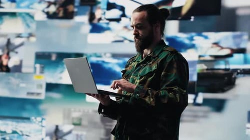 Man With Laptop in Front of Screens