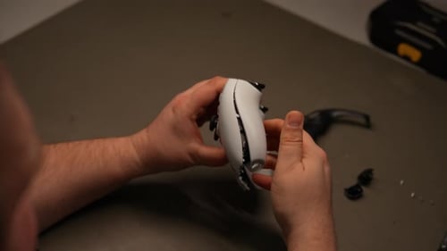 Closeup of Technician Hands Examining Internal Components of Disassembled Joystick Controller