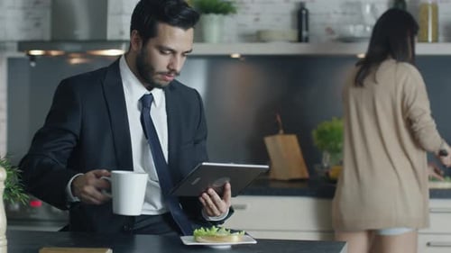Man in Suit Uses Tablet in Modern Kitchen