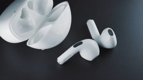 Wireless Earbuds with Charging Case on Dark Surface