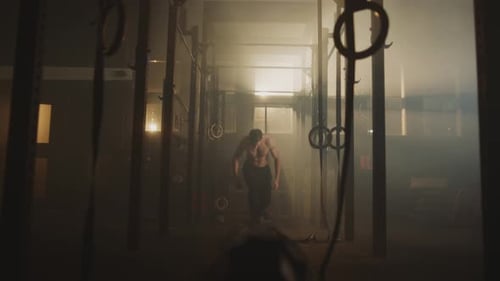 Muscular Man Working Out With Battle Ropes in Gym
