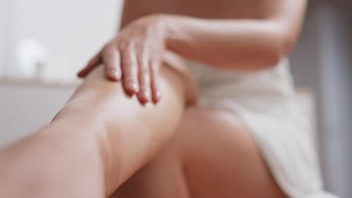Femme faisant un massage des pieds dans un salon de spa à domicile, soins de la peau des pieds, fille en serviette blanche faisant un massage