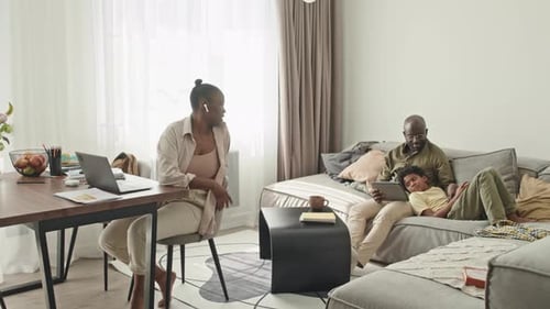 Family Relaxing at Home on Laptop and Tablet