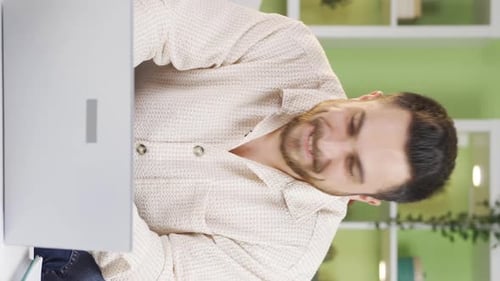 Man Celebrating Success with Laptop in Home Office