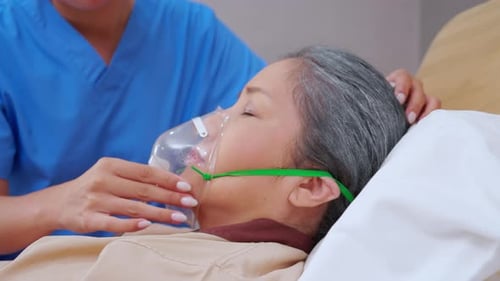 Nurse putting oxygen mask with patient elderly woman on bed for diagnose and healing in hospital.