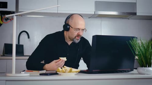 Man Eating Lunch While Video Conferencing at Home
