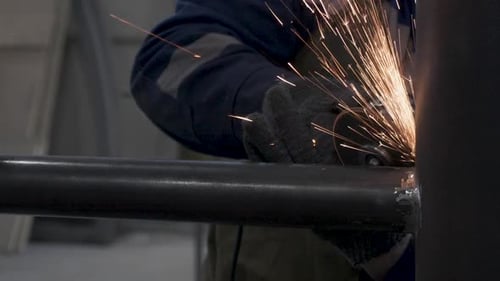 Un trabajador muele una estructura metálica