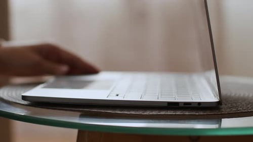 Woman Opens Laptop on a Glass Table